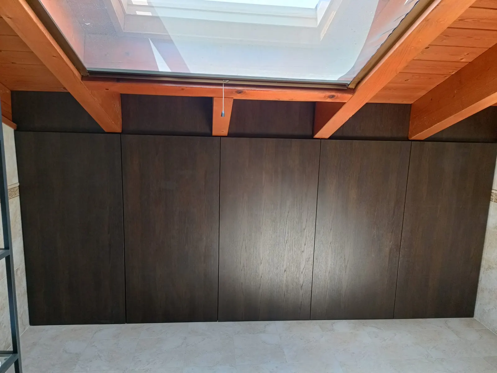 Armadiatura sottotetto in legno scuro sotto travi a vista